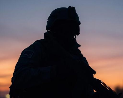 Silhouette of a US military personnel patrolling at dusk